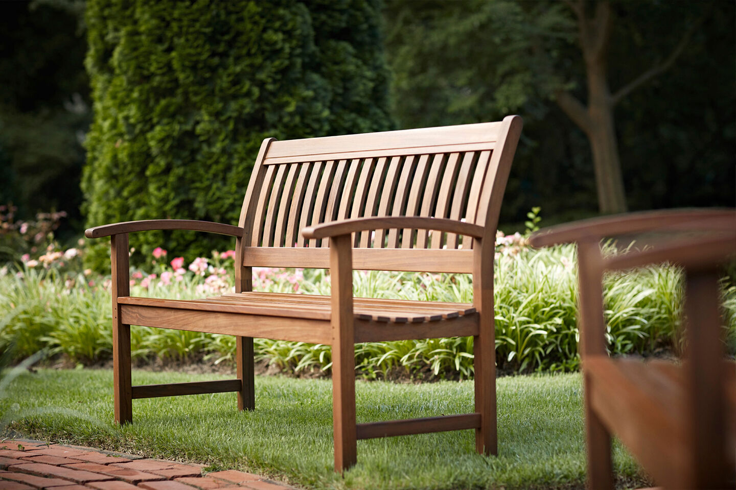 Classic Ipe bench by Jensen Outdoor in lush backyard