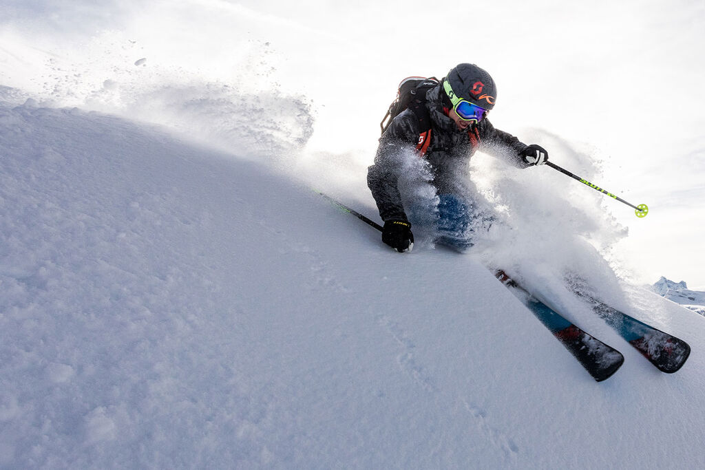 Skier shredding through a pow field