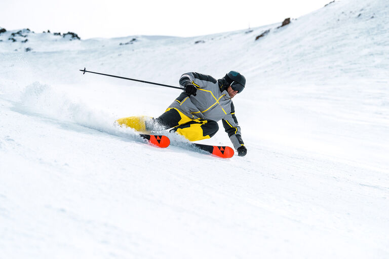 Male skier in Spyder apparel carving through snow
