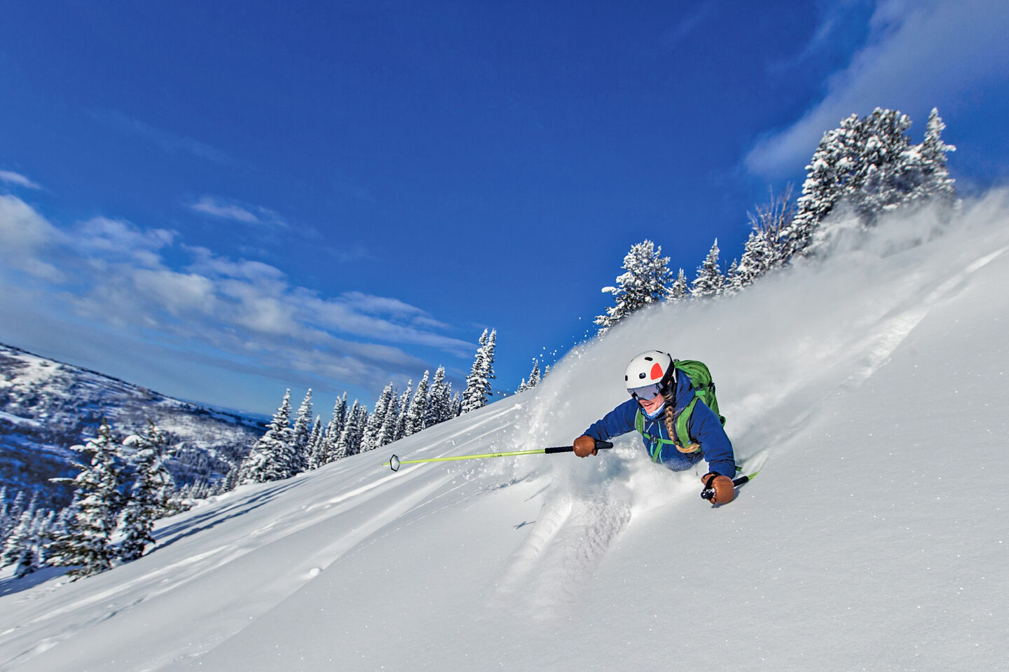 Skier in deep powder with blue skies