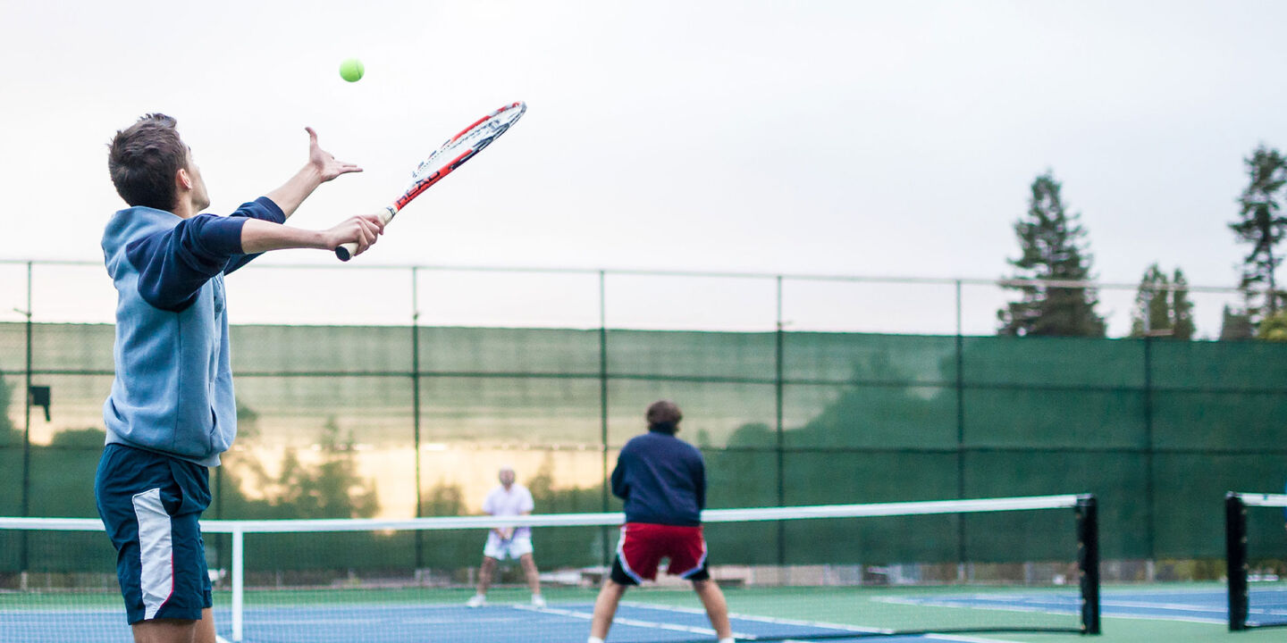 Tennis player playing doubles preparing to serve