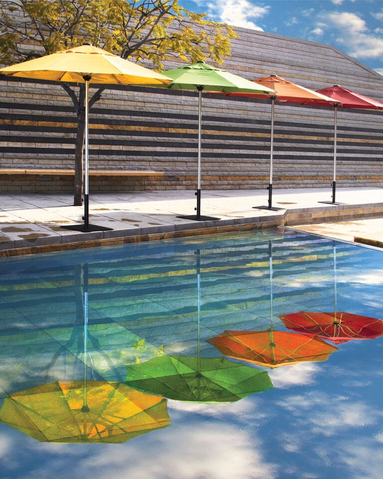 Colorful commercial patio umbrellas next to pool