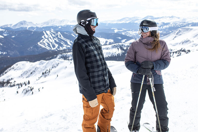 Skier and snowboarder chatting on the mountain