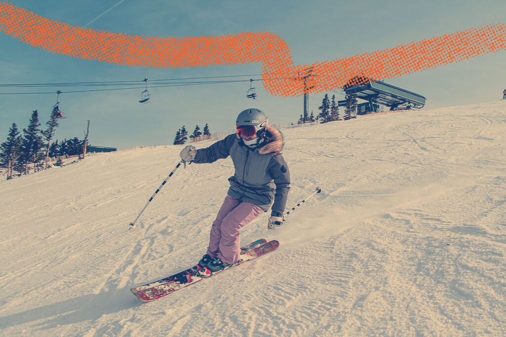 Female skier carving in front of the chairlift