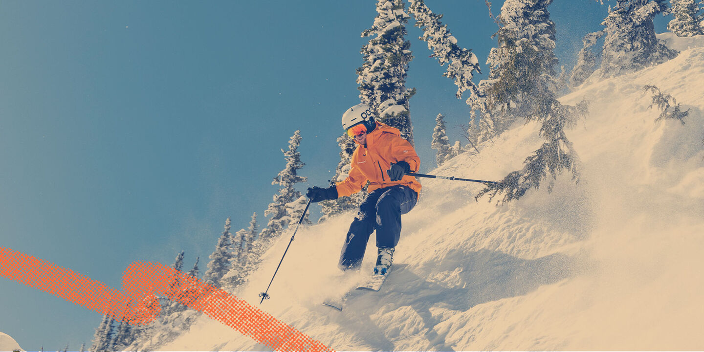 Skier carving on mountain with blue skies