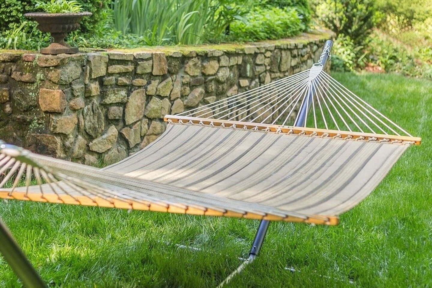 Padded hammock in backyard on bright green grass