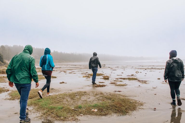 group of people cleaning up trash on beach
