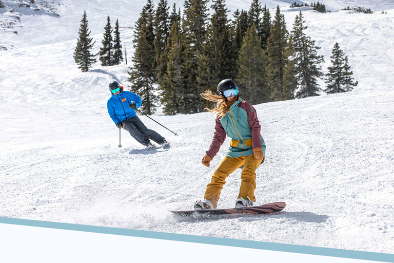 Skier and snowboarder on a groomer