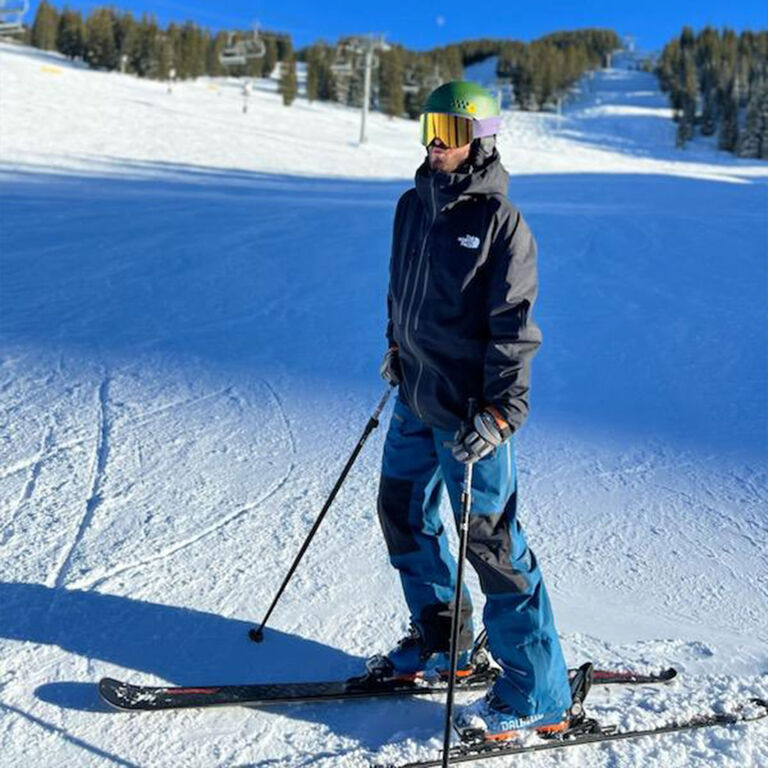 Jay R wearing ski gear standing on a ski run Jay R wearing ski gear standing on a ski run