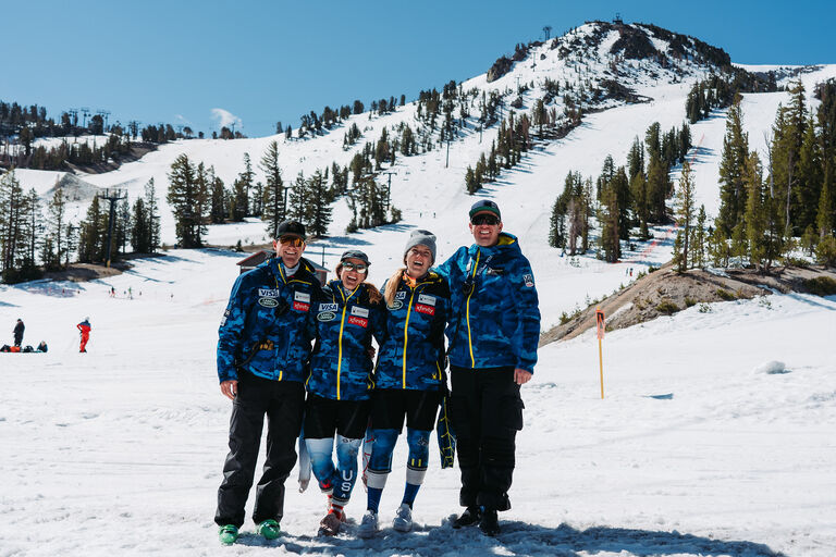 US Ski and Snowboard team standing at base of mountian