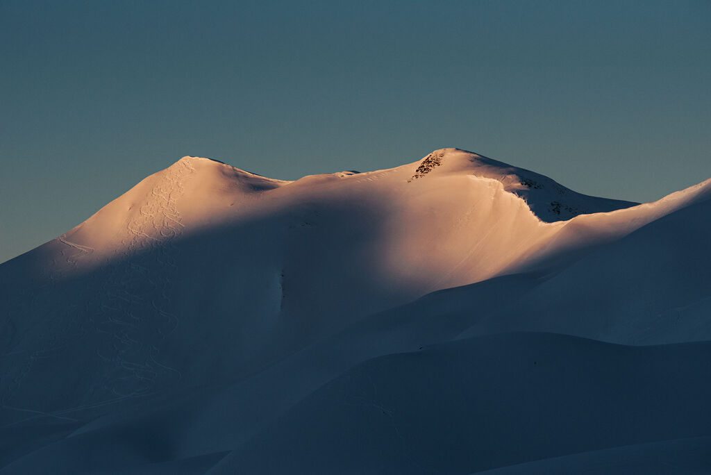Mountain peaks with ski tracks through freshly fallen snow