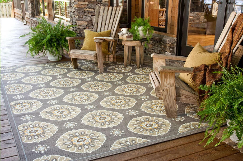 Outdoor rug with two Adirondack chairs on a covered patio
