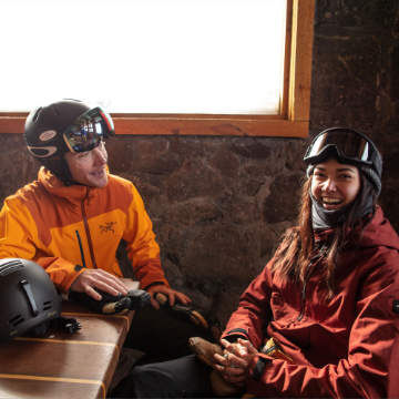 two skiers sitting in a lodge