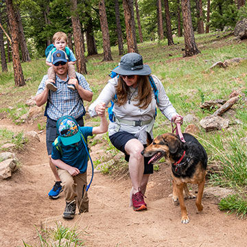 Family with their dog outside enjoying a hike
