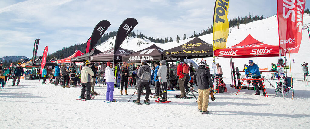 ski and snowboard event at the base of a mountain with vendor tents