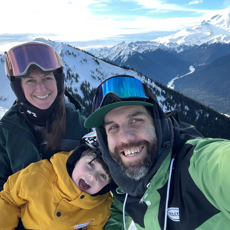 Larry D smiling with his family with mountains in the background